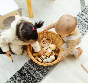 Toddlers exploring a treasure basket during sensory play